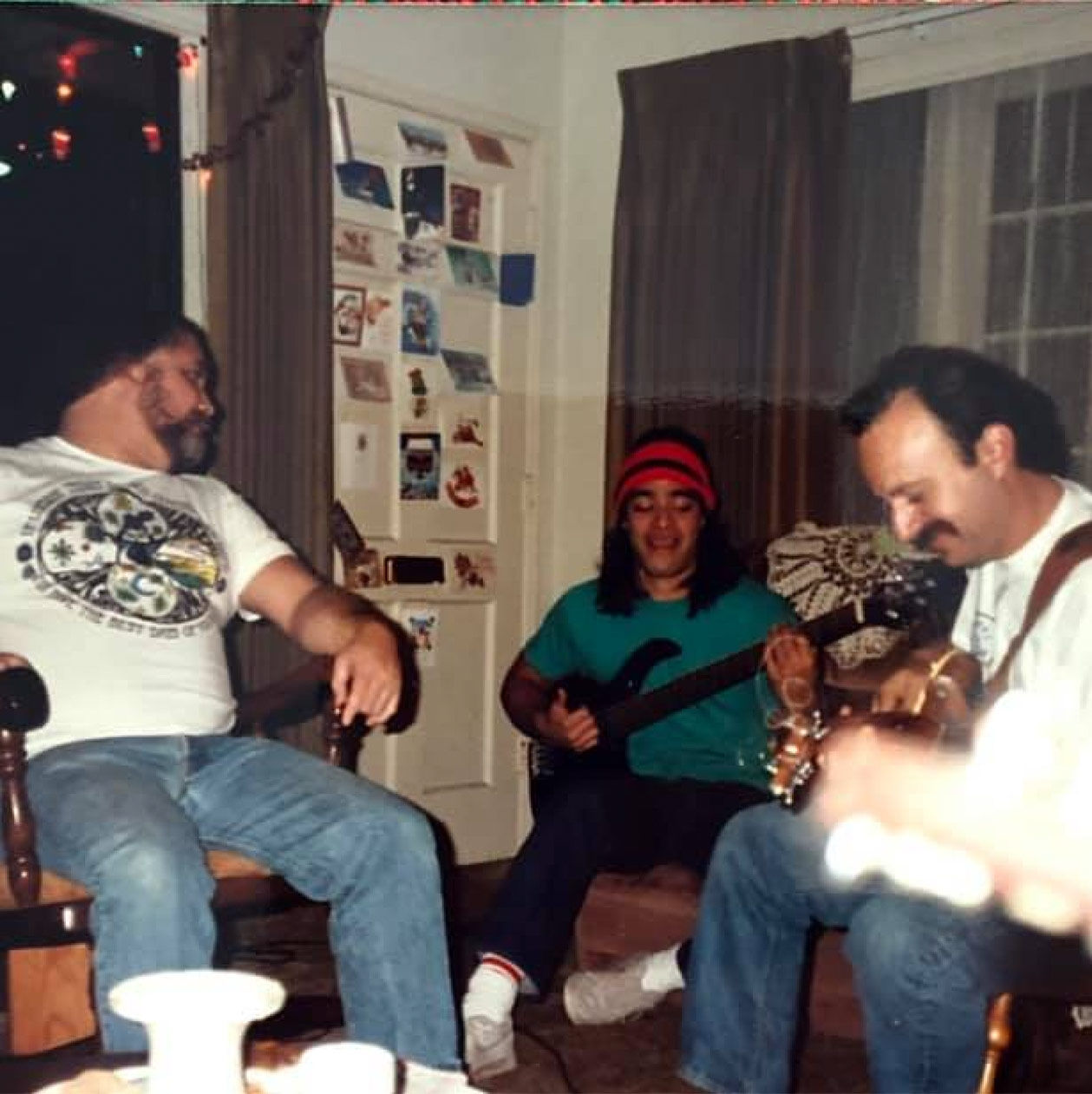 Three people playing music in a living room